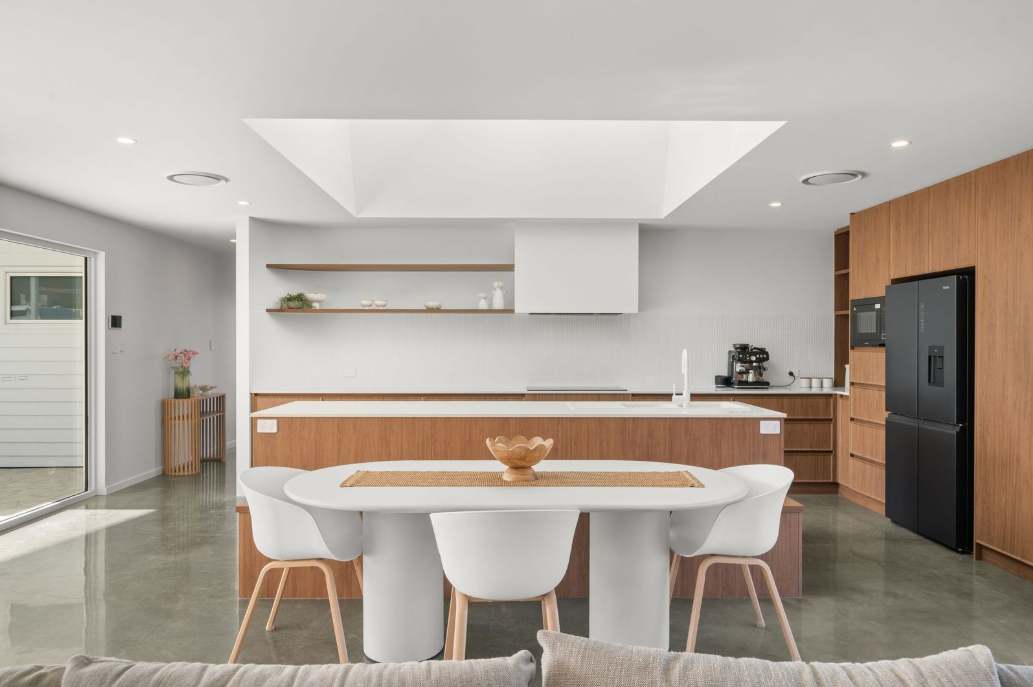 Open kitchen and dining space beneath a skylight