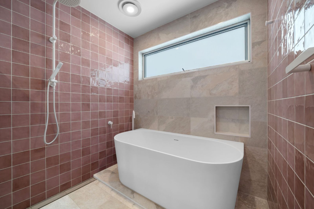 Rose tiled bathroom with freestanding bath and shower
